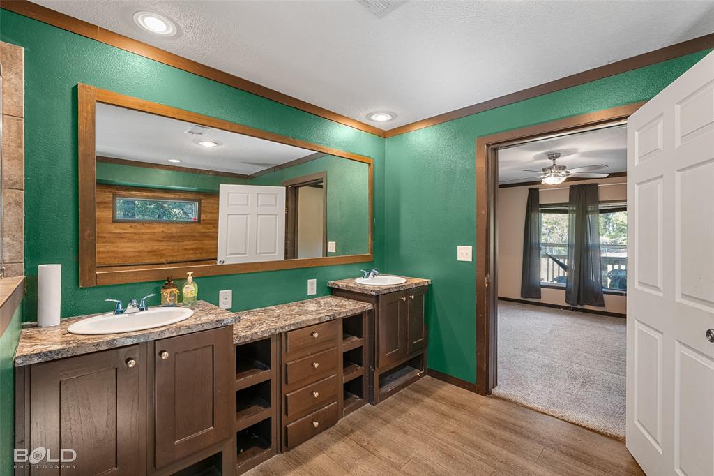 9489 Capps City Road Rodessa, LA 71069 - Photo 29 of 34 a bathroom with a double vanity sink and a mirror