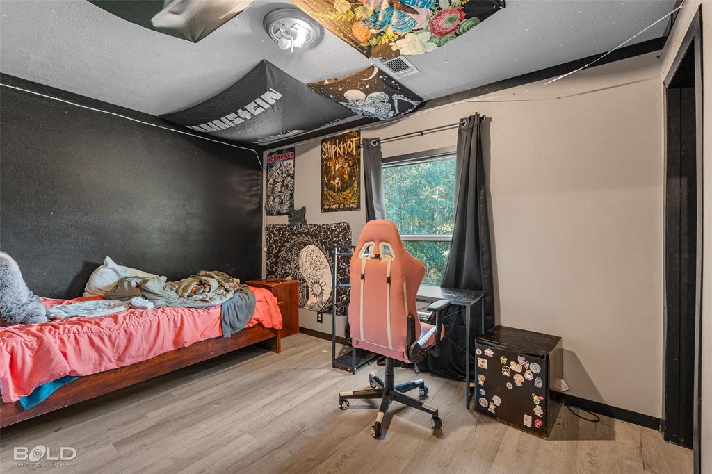 9489 Capps City Road Rodessa, LA 71069 - Photo 30 of 34 a bedroom with bed and wooden floor