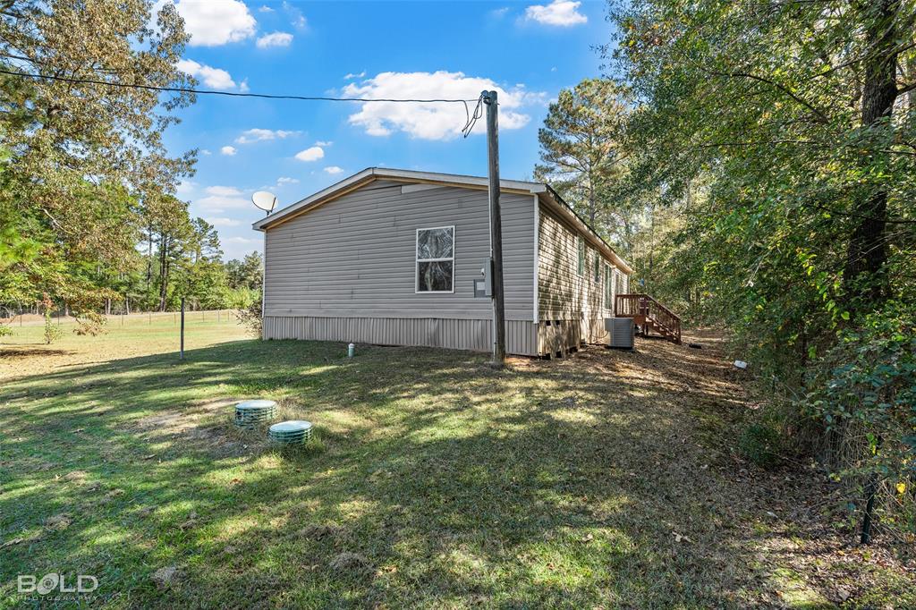 9489 Capps City Road Rodessa, LA 71069 - Photo 9 of 34 a backyard of a house with table and chairs