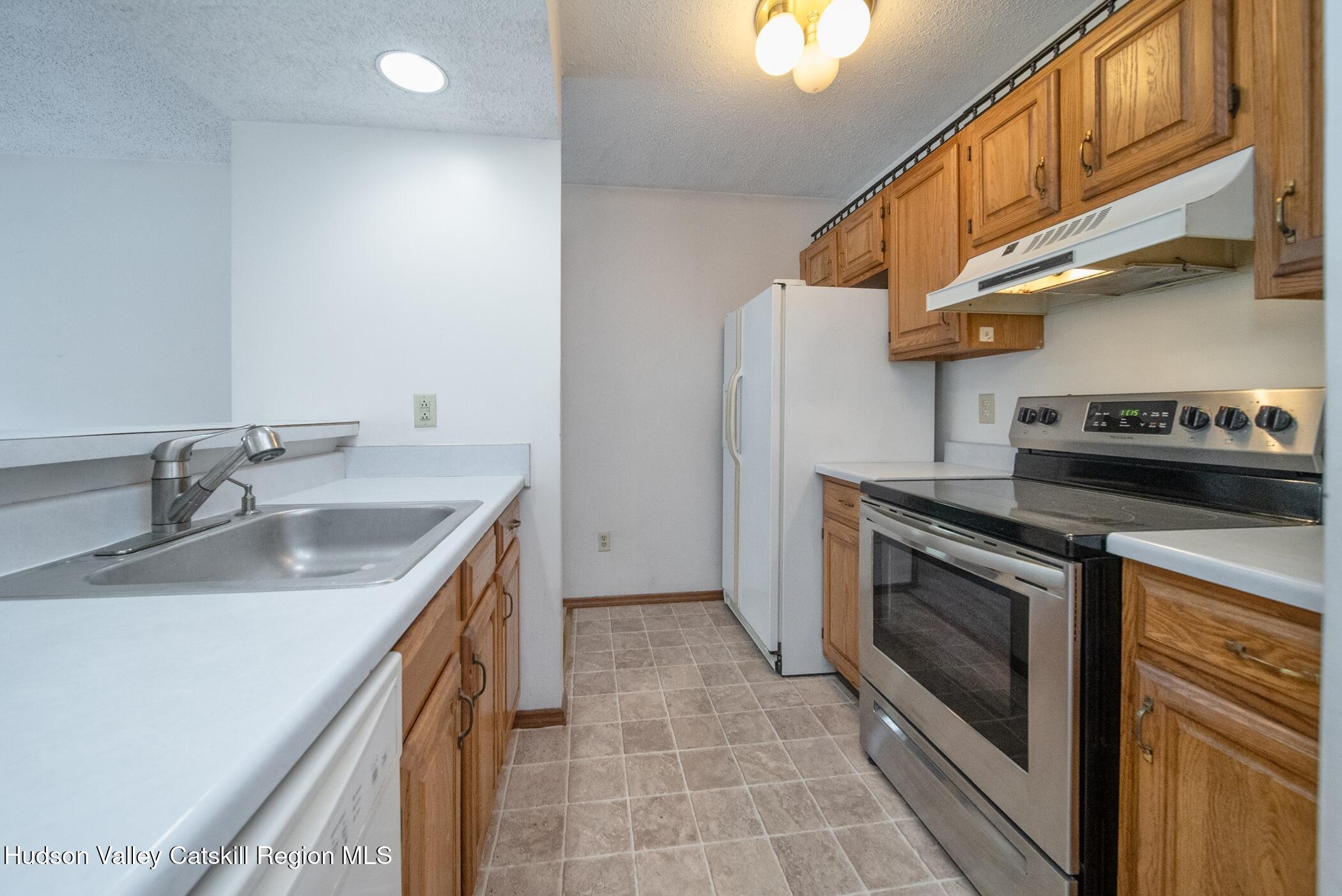 9 Rock Maple Road Saugerties, NY 12477 - Photo 6 of 30 a kitchen with stainless steel appliances granite countertop a sink a stove and a wooden cabinets