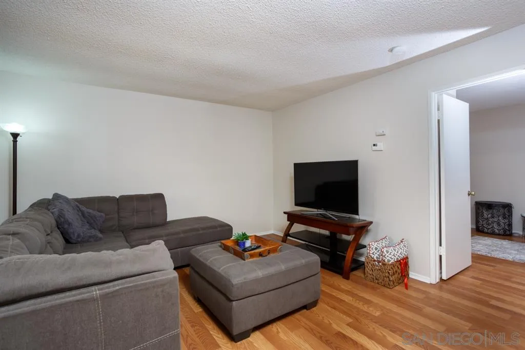8558 Summerdale Road, Unit 133 San Diego, CA 92126 - Photo 3 of 14 a living room with furniture and a flat screen tv