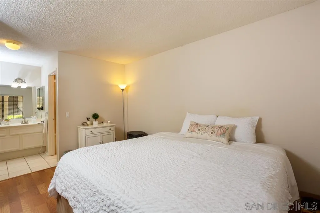 8558 Summerdale Road, Unit 133 San Diego, CA 92126 - Photo 7 of 14 a bedroom with a bed and wooden floor