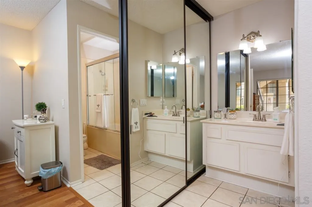 8558 Summerdale Road, Unit 133 San Diego, CA 92126 - Photo 8 of 14 a bathroom with a double vanity sink a mirror and shower