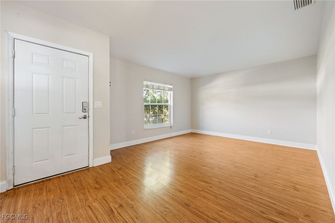 14150 Benedict Street Fort Myers, FL 33905 - Photo 10 of 31 an empty room with wooden floor and windows