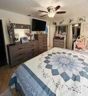 a bed room with a bed a television and dresser