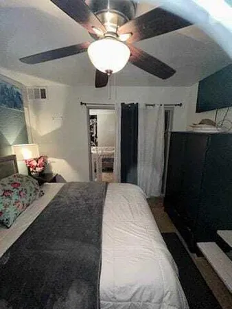 a bed room with a bed mirror and a ceiling fan