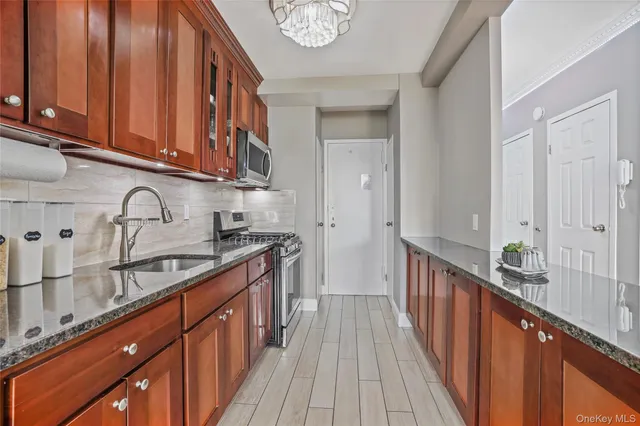 a kitchen with granite countertop a sink and stove top oven