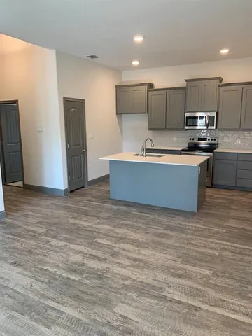 a kitchen with stainless steel appliances a refrigerator and a stove top oven