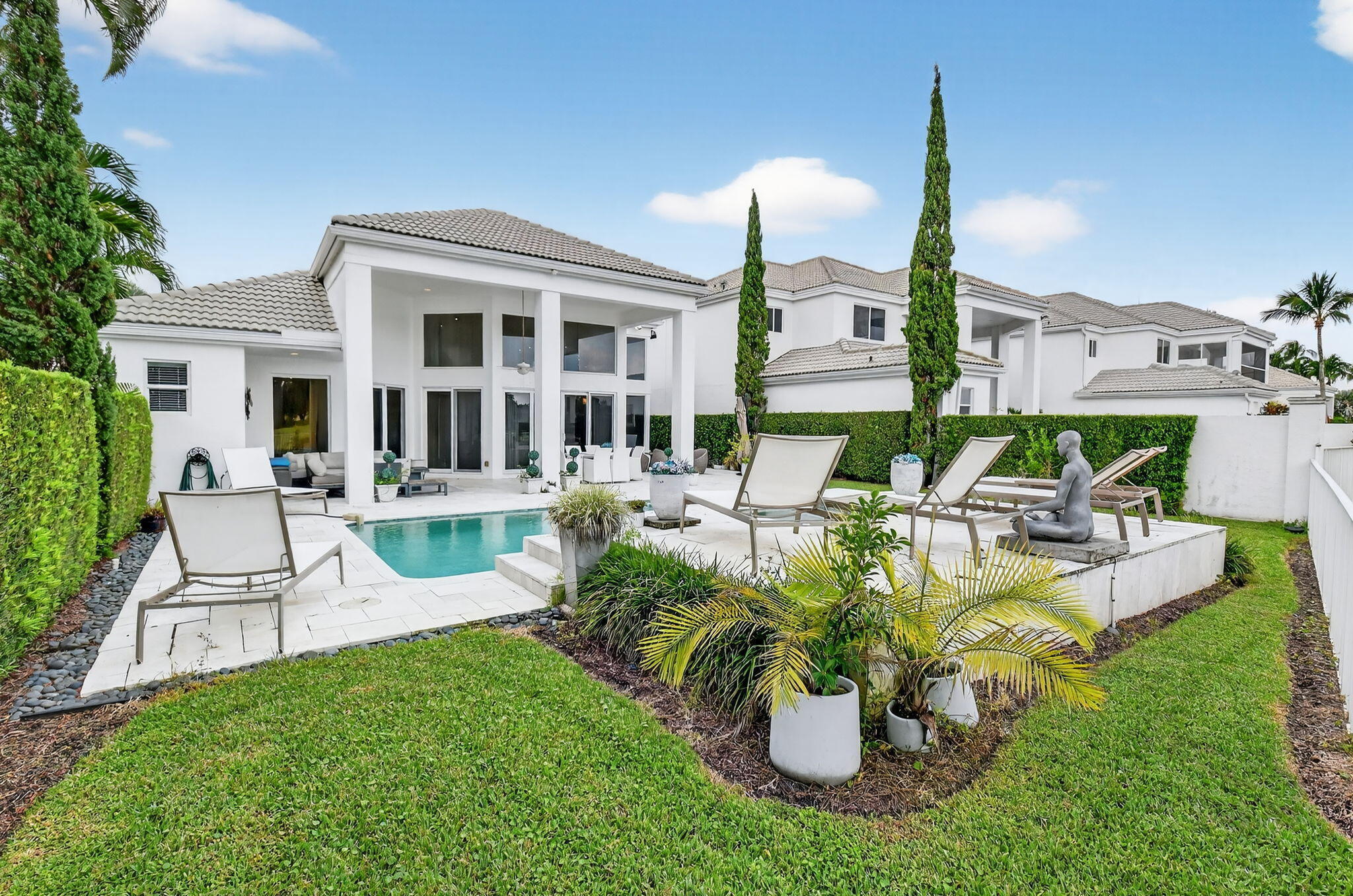 2563 Northwest 63rd Street Boca Raton, FL 33496 - Photo 45 of 65 a view of a house with patio outdoor dining table and chairs
