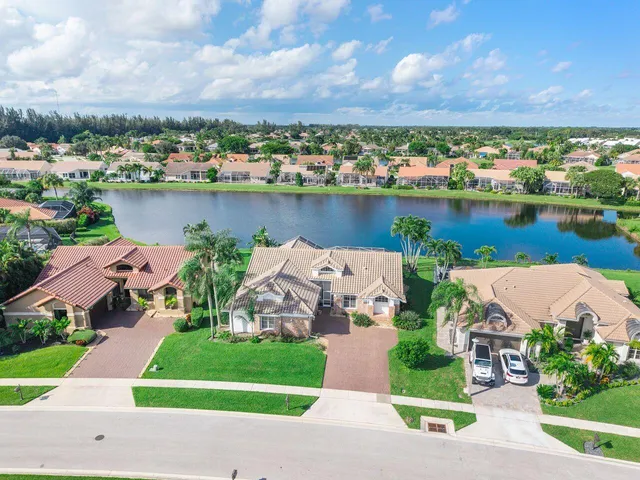 an aerial view of a house with a garden and lake view