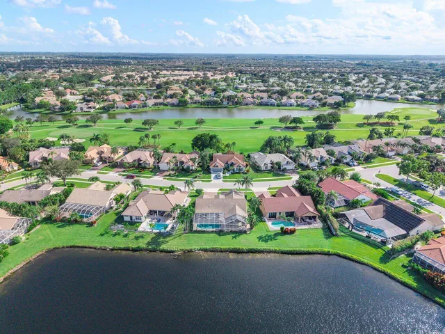 a view of a big house with a big yard plants and large trees