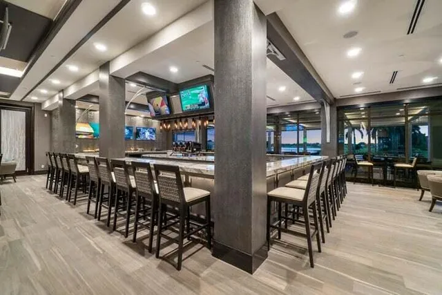 a large hall with lots of chairs a large window and a clock