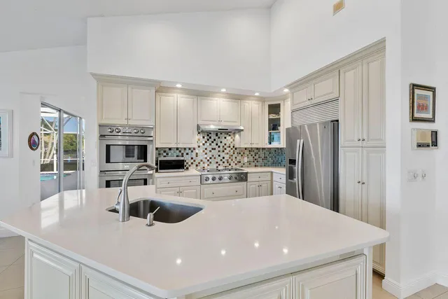 a kitchen with stainless steel appliances a sink a stove a microwave and cabinets