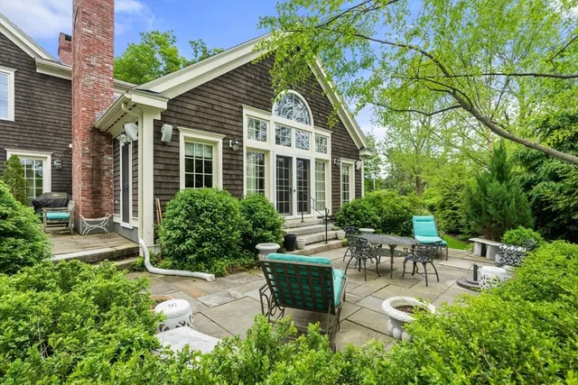 a view of a chair and table in backyard of the house