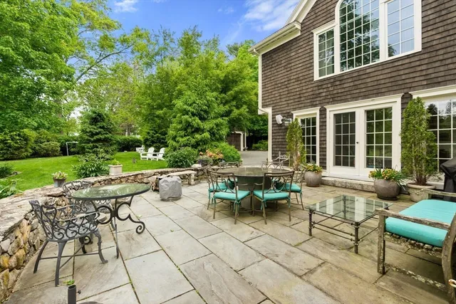 a view of a patio with table and chairs potted plants and a palm tree