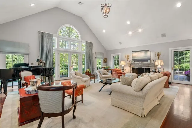 a living room with fireplace furniture and a large window
