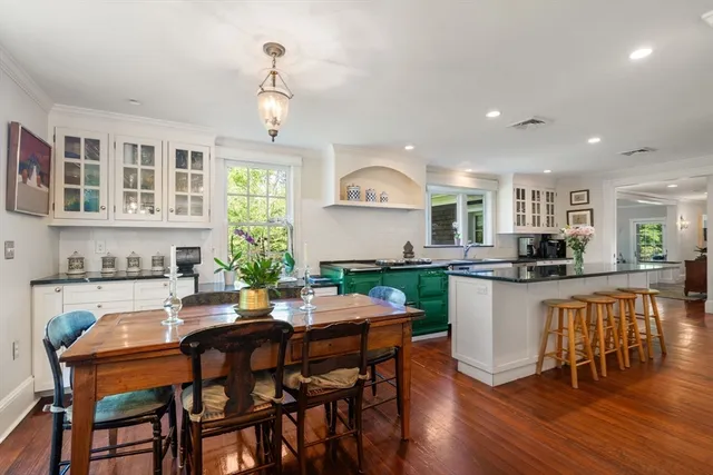 a kitchen with a dining table chairs and microwave