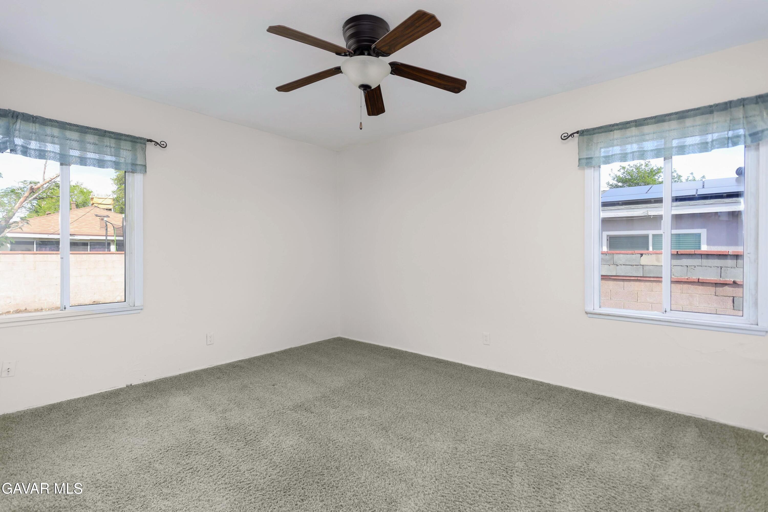 44265 Foxton Avenue Lancaster, CA 93535 - Photo 12 of 20 an empty room with a window and a fan