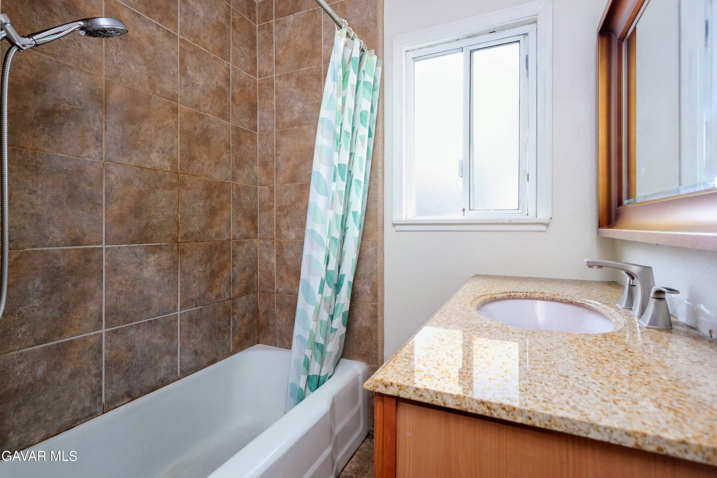 44265 Foxton Avenue Lancaster, CA 93535 - Photo 16 of 20 a bathroom with a granite countertop sink and bathtub
