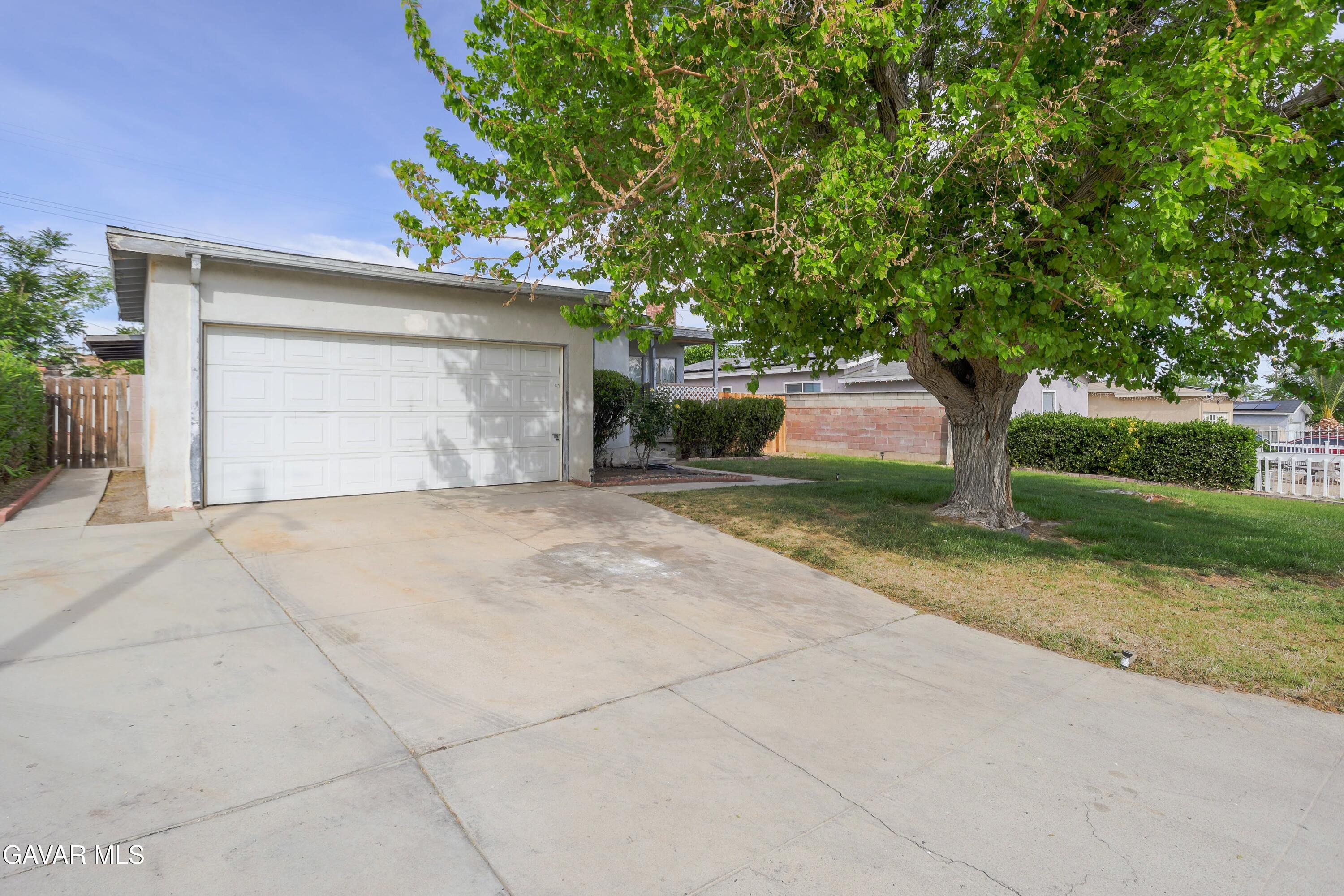 44265 Foxton Avenue Lancaster, CA 93535 - Photo 2 of 20 a front view of a house with a yard and garage