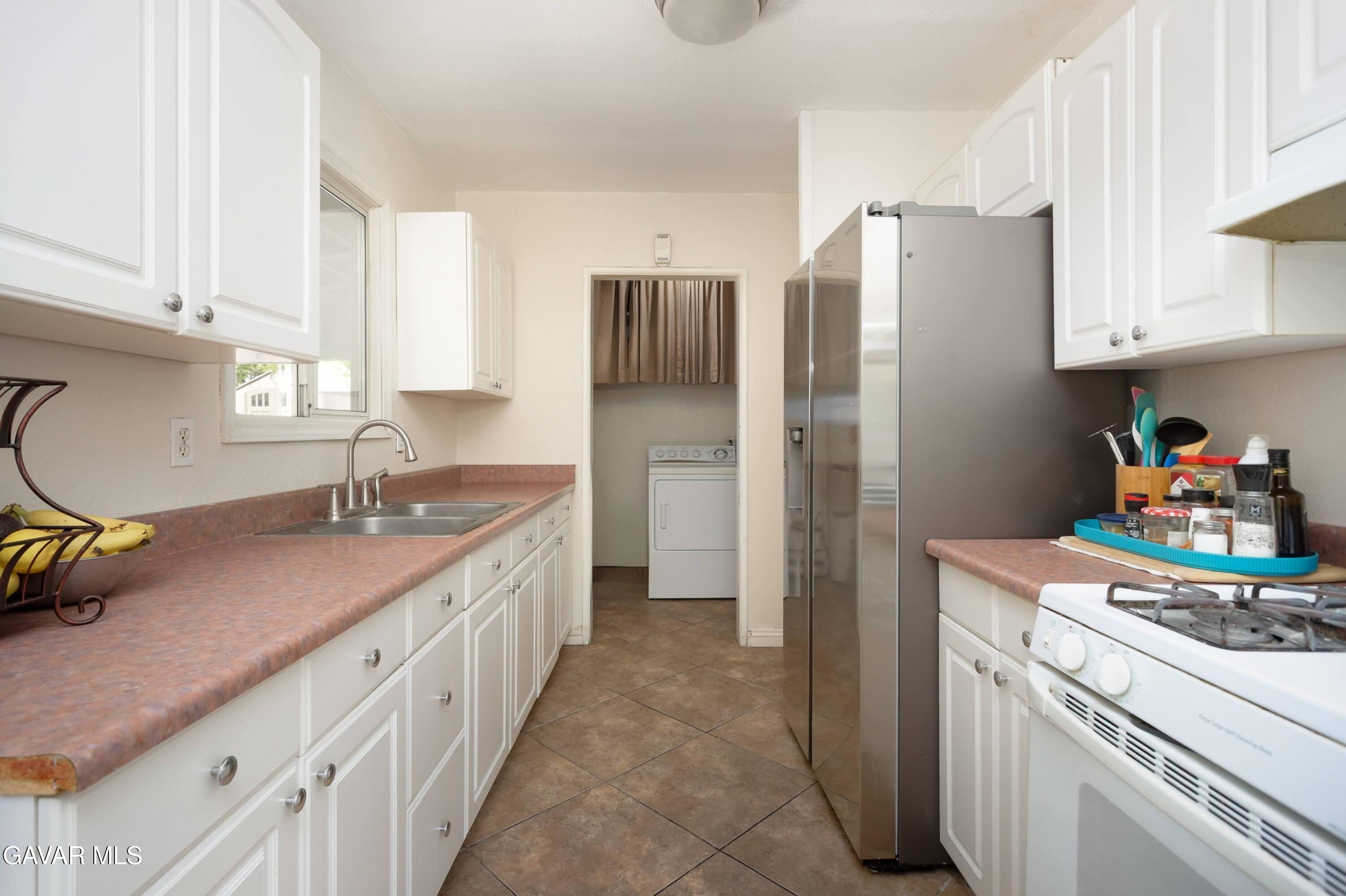44265 Foxton Avenue Lancaster, CA 93535 - Photo 9 of 20 a kitchen with a sink stove and refrigerator