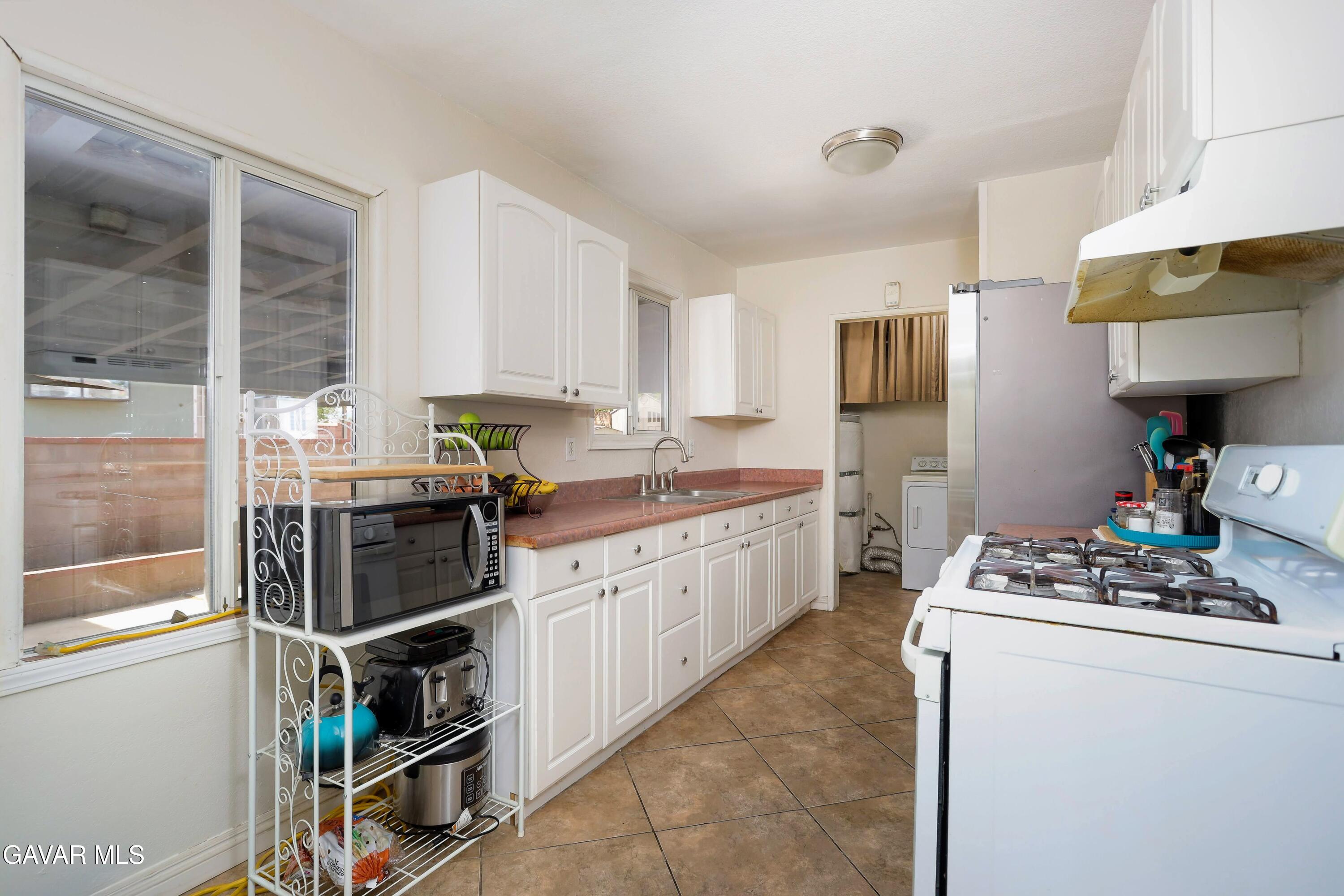 44265 Foxton Avenue Lancaster, CA 93535 - Photo 10 of 20 a kitchen that has a lot of cabinets in it and appliances