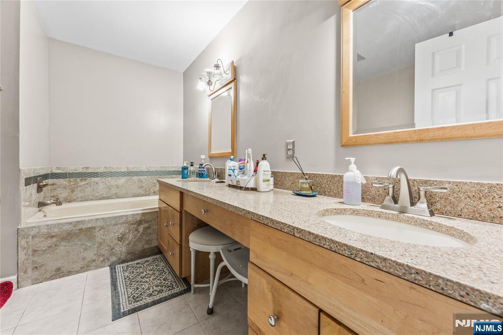 123 Butternut Drive Wayne, NJ 07470 - Photo 15 of 23 a bathroom with a granite countertop bathtub sink vanity and mirror