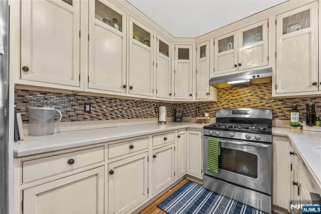 a kitchen with granite countertop white cabinets and white appliances