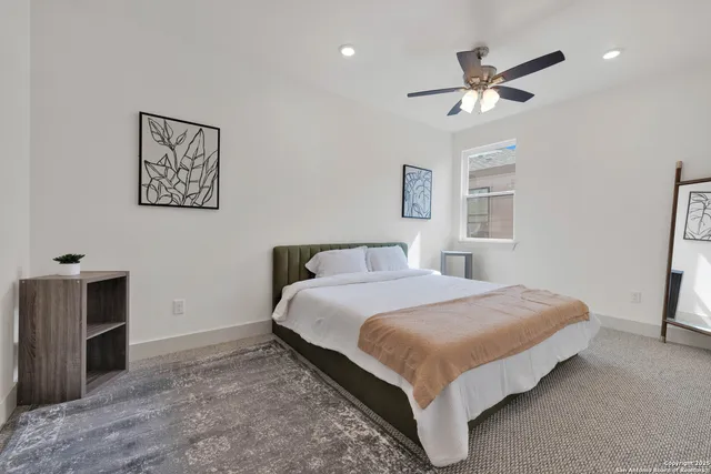 a bedroom with a bed and painting on the wall