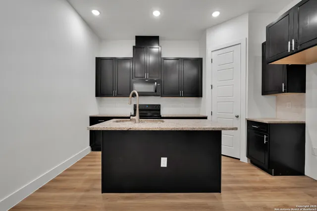a kitchen with stainless steel appliances granite countertop a sink stove and refrigerator
