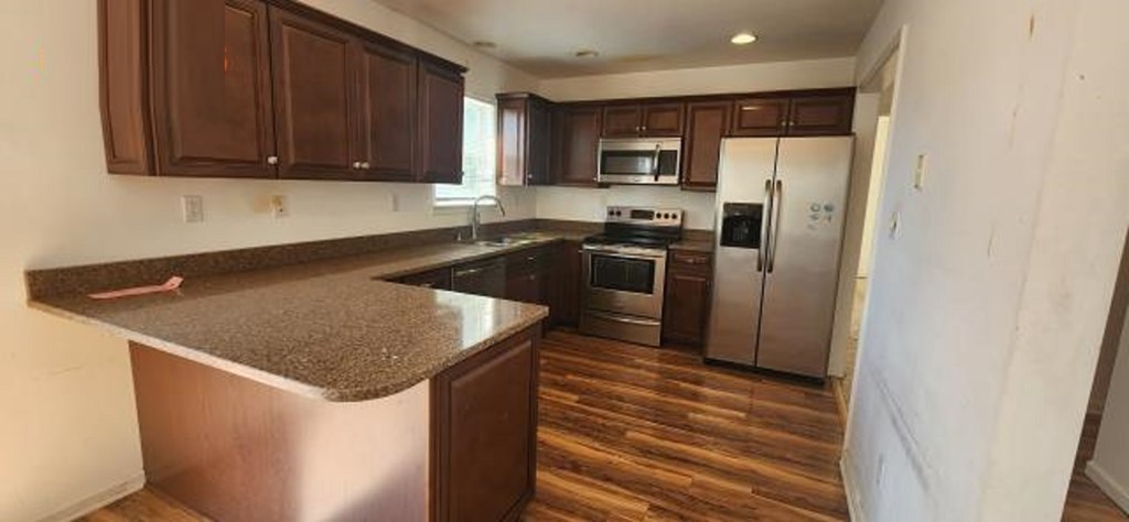 2402 Octopus Road Greenbackville, VA 23356 - Photo 5 of 21 a kitchen with stainless steel appliances granite countertop a refrigerator a sink a stove a microwave and island with wooden floor