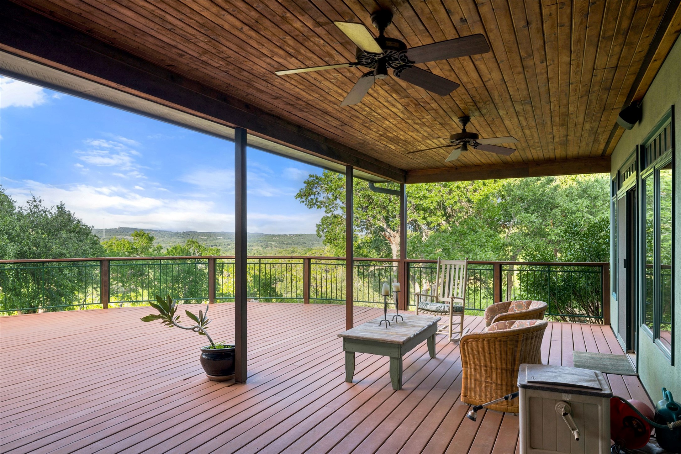 505 Red Corral Ranch Road Wimberley, TX 78676 - Photo 34 of 40 A spacious, covered deck extends gracefully into verdant tree canopy with distant views.