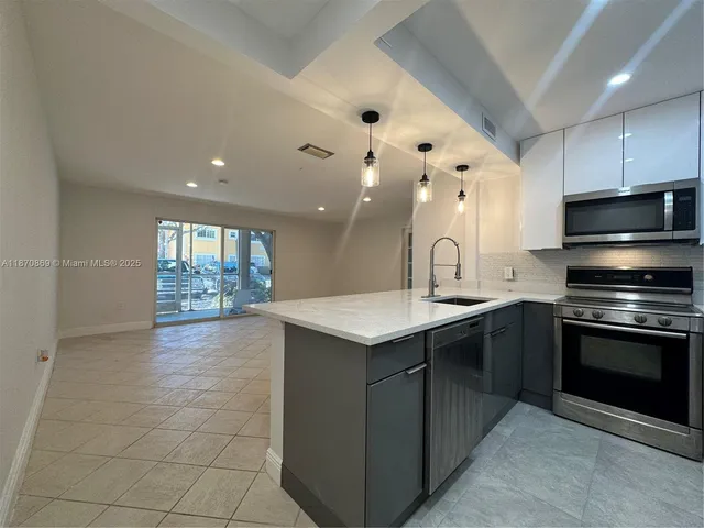 a kitchen with a sink cabinets and stainless steel appliances