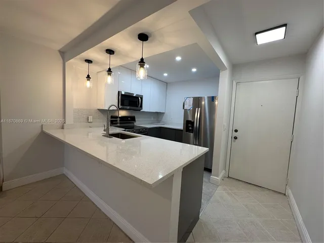 a kitchen with kitchen island a sink stainless steel appliances and cabinets