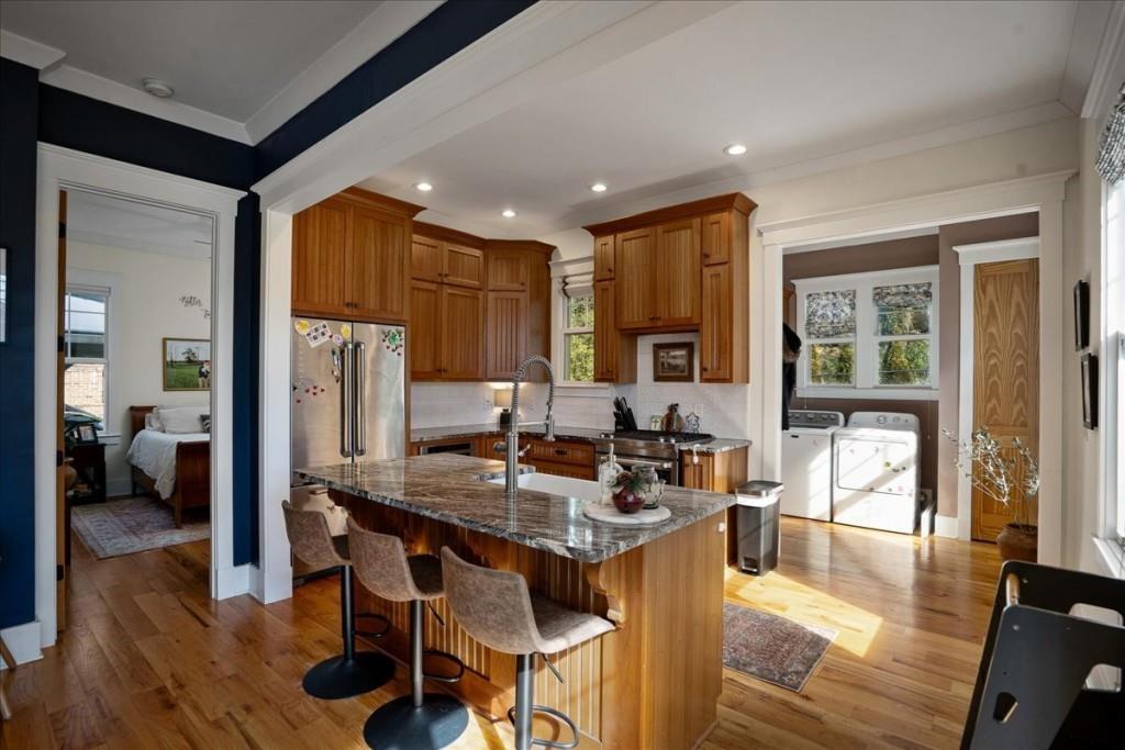 435 Walton Street Monroe, GA 30655 - Photo 15 of 55 a kitchen with granite countertop kitchen island stainless steel appliances a table and chairs