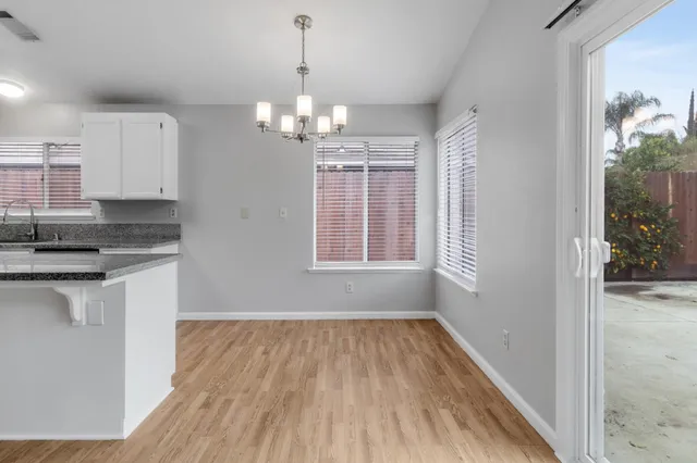 a view of a kitchen with granite countertop stainless steel appliances sink and wooden floor