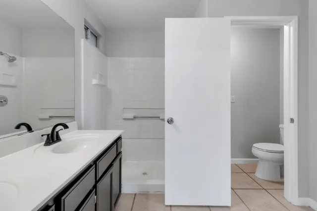 a bathroom with a sink a toilet and shower