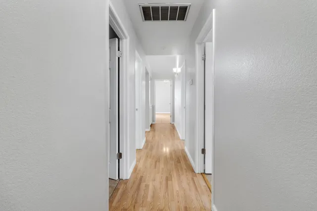 a view of a hallway with wooden floor