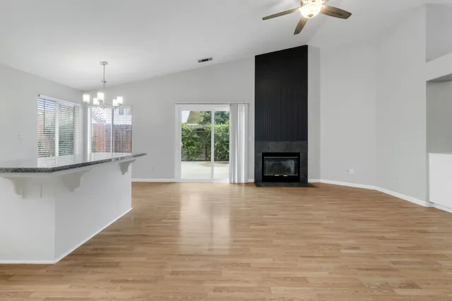 a view of a livingroom with a fireplace wooden floor and chandelier
