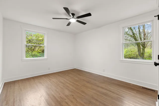 a view of a big room with wooden floor and a window