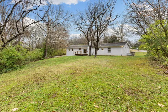 a view of a yard with a house and large trees