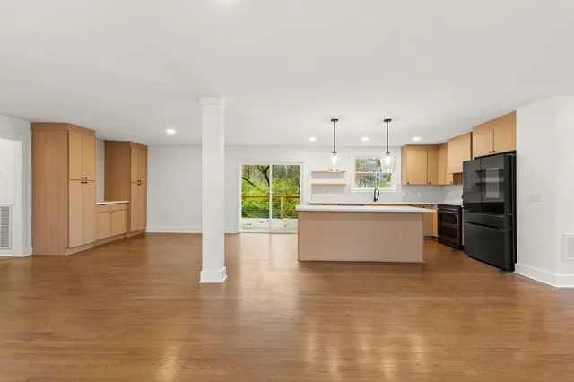 a large kitchen with stainless steel appliances kitchen island granite countertop a stove top oven a sink and a refrigerator