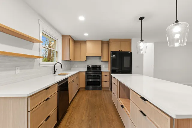 a large kitchen with stainless steel appliances granite countertop a sink and dishwasher a stove with wooden floor