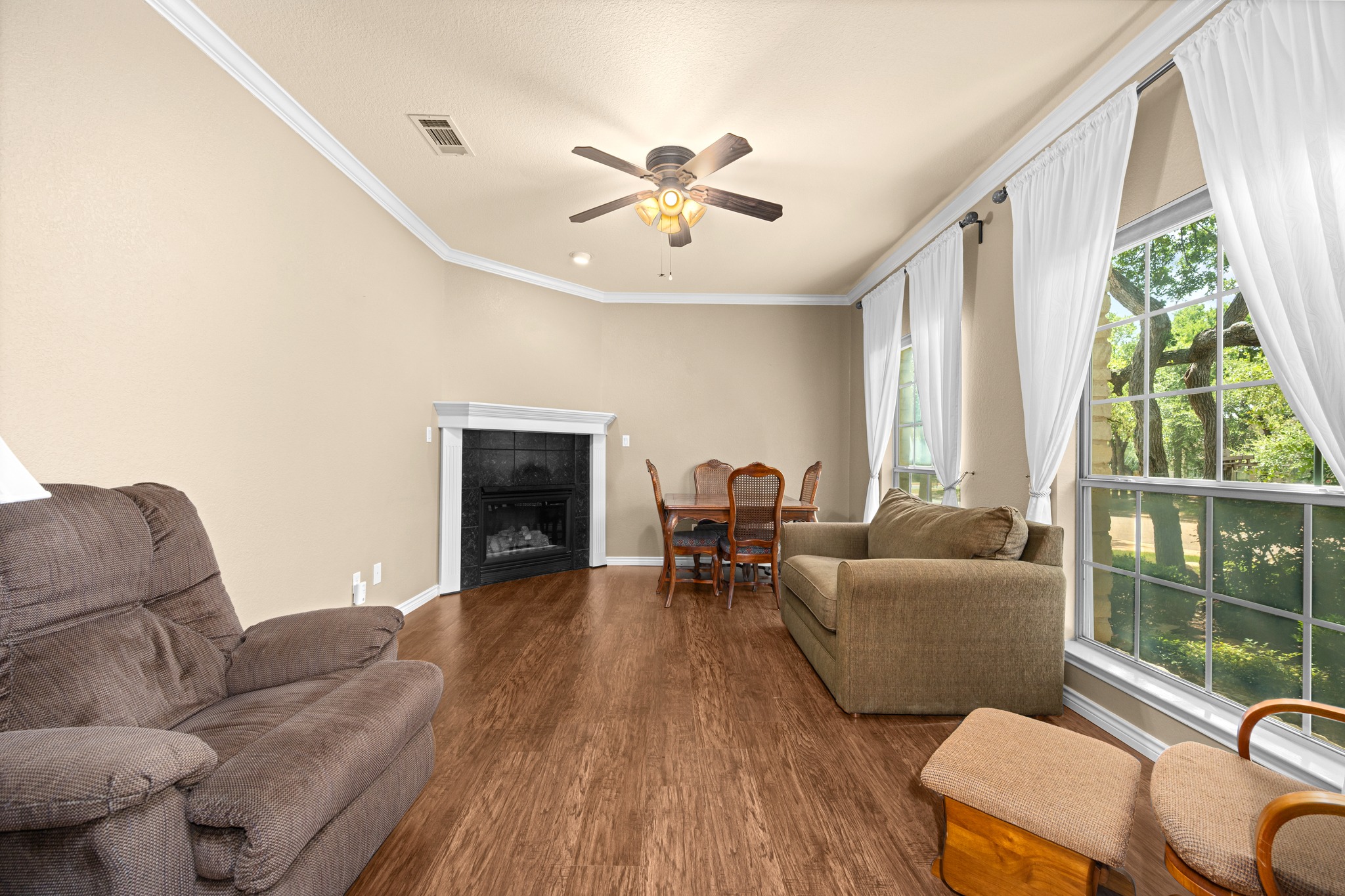 108 Thornwood Road Georgetown, TX 78628 - Photo 7 of 40 A welcoming living space features a corner fireplace, durable flooring, and ample natural light.