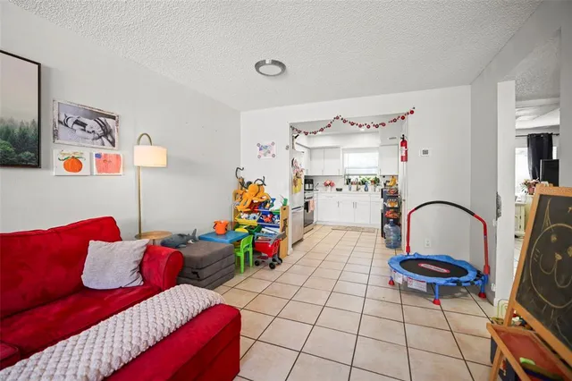 a bed room with a bed a couch and a flat tv screen