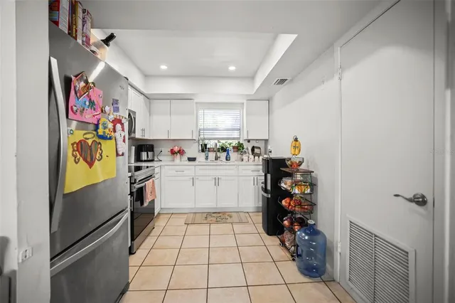 a kitchen with granite countertop cabinets stainless steel appliances and a window