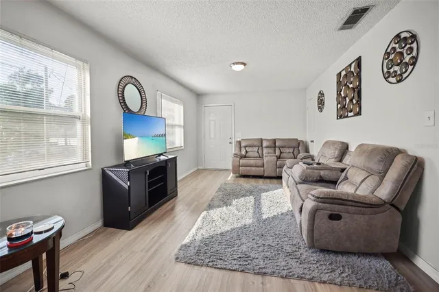 a living room with furniture and a wooden floor