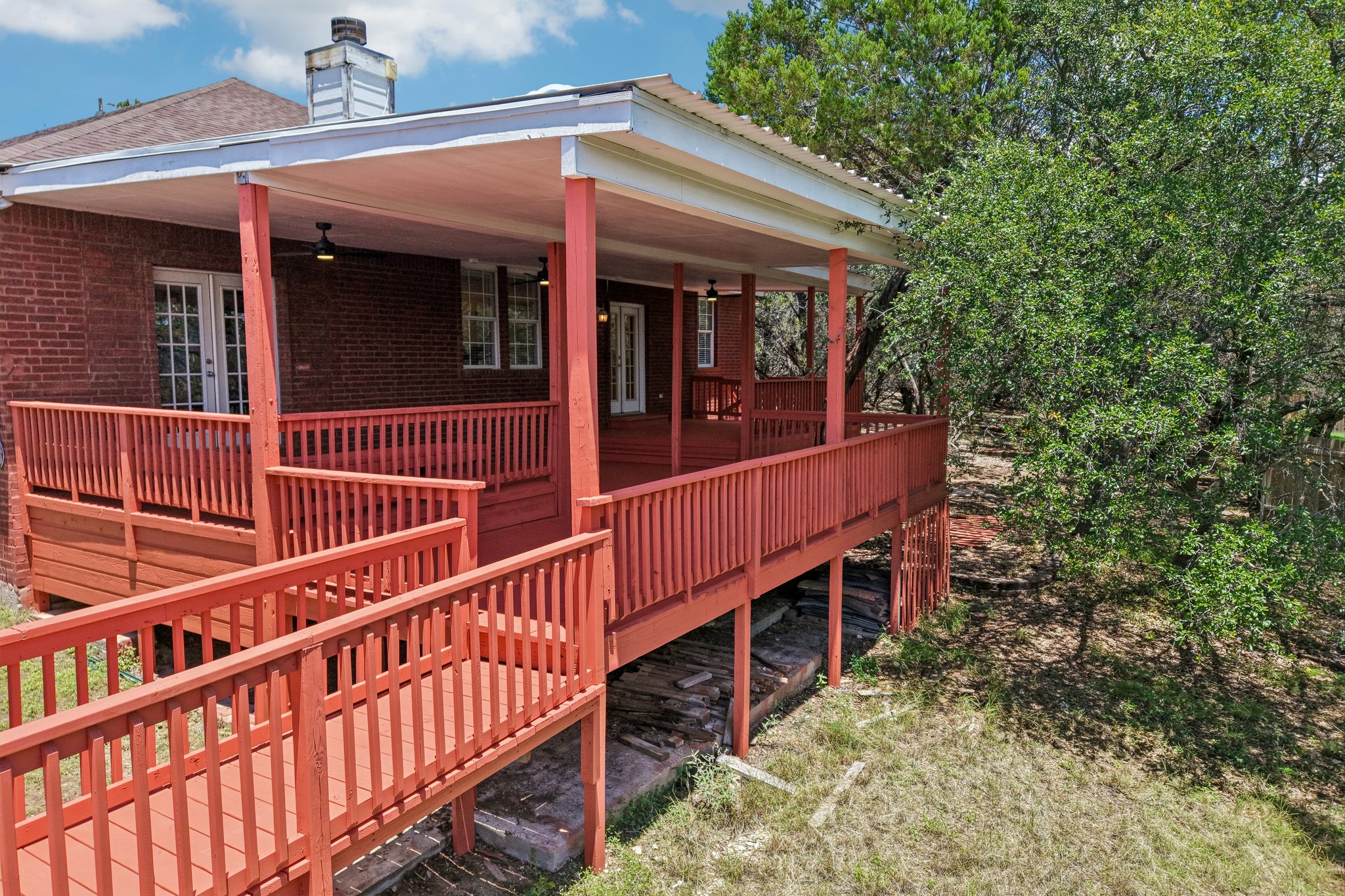 20609 Bridle Path Road Lago Vista, TX 78645 - Photo 20 of 30 An inviting covered deck with a wheelchair ramp overlooks a serene, treed backyard.