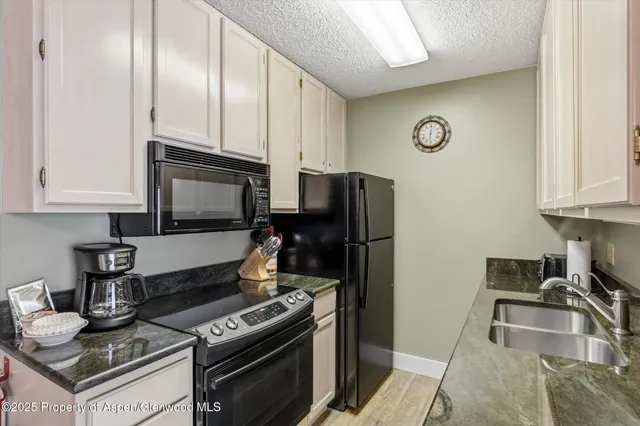 a kitchen with stainless steel appliances granite countertop a sink stove and cabinets