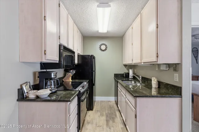 a kitchen with granite countertop a sink and cabinets